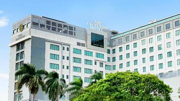 A multi-story hotel building with a modern architectural design, featuring a prominent sign at the top.