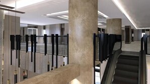 A modern interior with a central staircase, large concrete columns, and a glass railing. - The Excelton Hotel (Palembang)