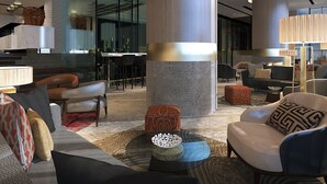 A modern lobby with high ceilings, large cylindrical columns, and contemporary furniture. - The Excelton Hotel (Palembang)