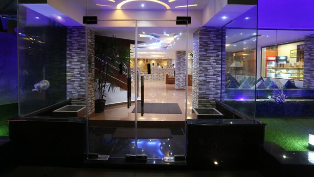A modern hotel lobby with a glass entrance, a reception desk, and a Coca-Cola refrigerator. - Hotel Eurolanka Colombo (Colombo)