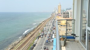 A coastal cityscape with a busy road parallel to the beach, high-rise buildings, and a clear view of the sea. - Hotel Eurolanka Colombo (Colombo)