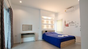 A modern bedroom with a bed, a desk, a mirror, and a wall-mounted air conditioner. - Le Leaf Pool Villa 7 (Hua Hin)