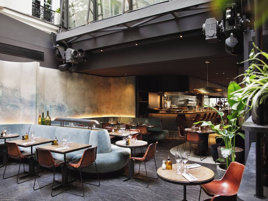 An indoor dining area with booths and tables, a bar area, and a kitchen in the background.