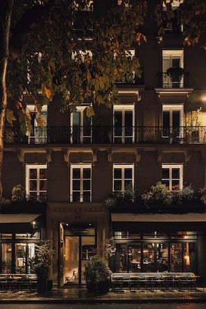 A multi-story building with balconies, a ground-level entrance, and outdoor seating. - Hôtel National Arts et Métiers (Paris)