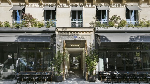Het uiterlijk van Hotel National des Arts et Metiers met een klassiek gevelontwerp, grote ramen en een terras.