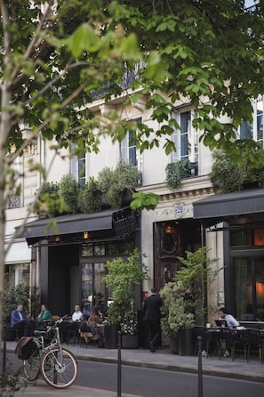 A cafe with outdoor seating, a bicycle parked outside, and a building with a number 243 sign. - Hôtel National Arts et Métiers (Paris)