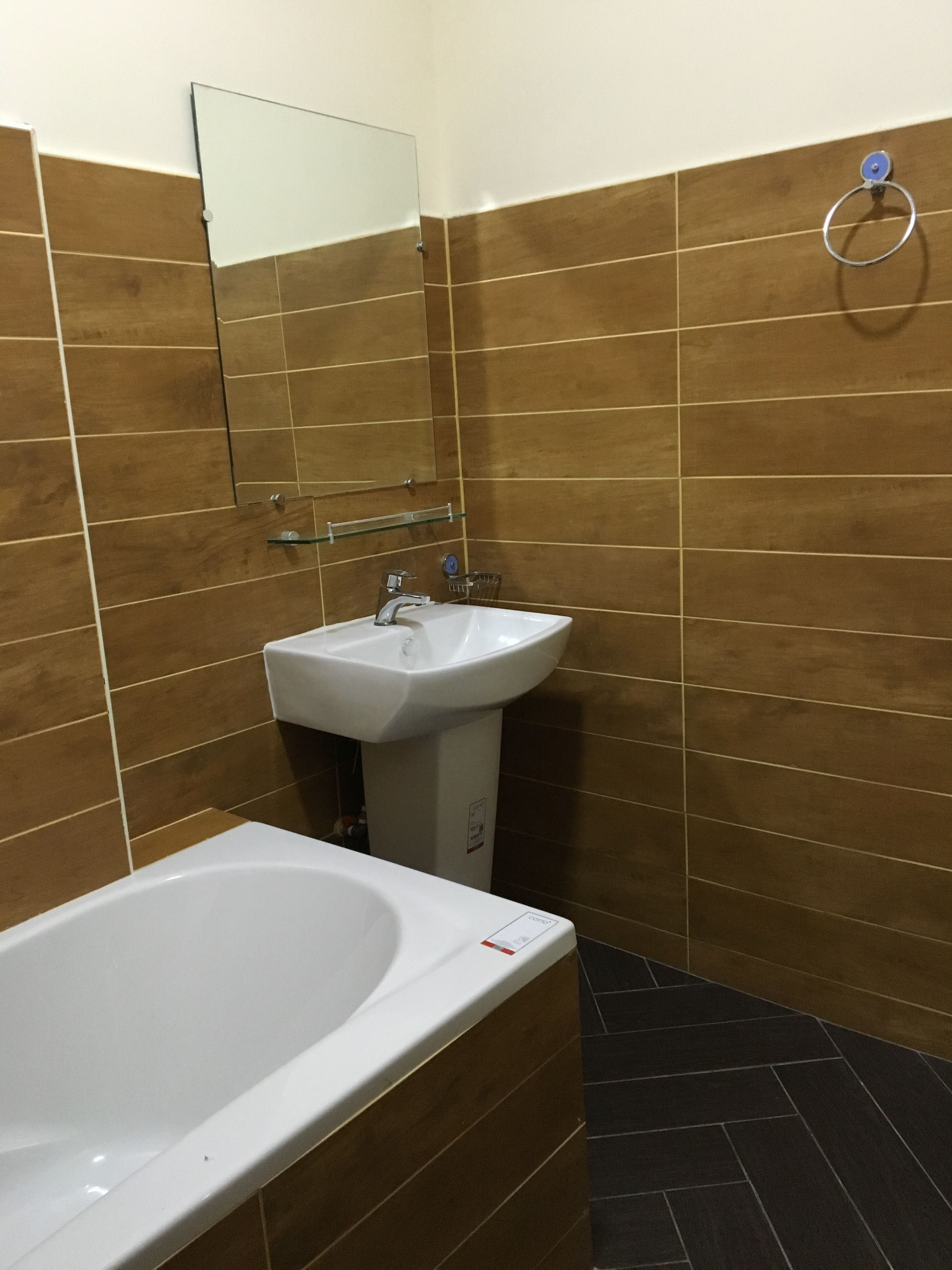 Un bagno con una vasca da bagno bianca, un lavandino bianco e uno specchio a parete.