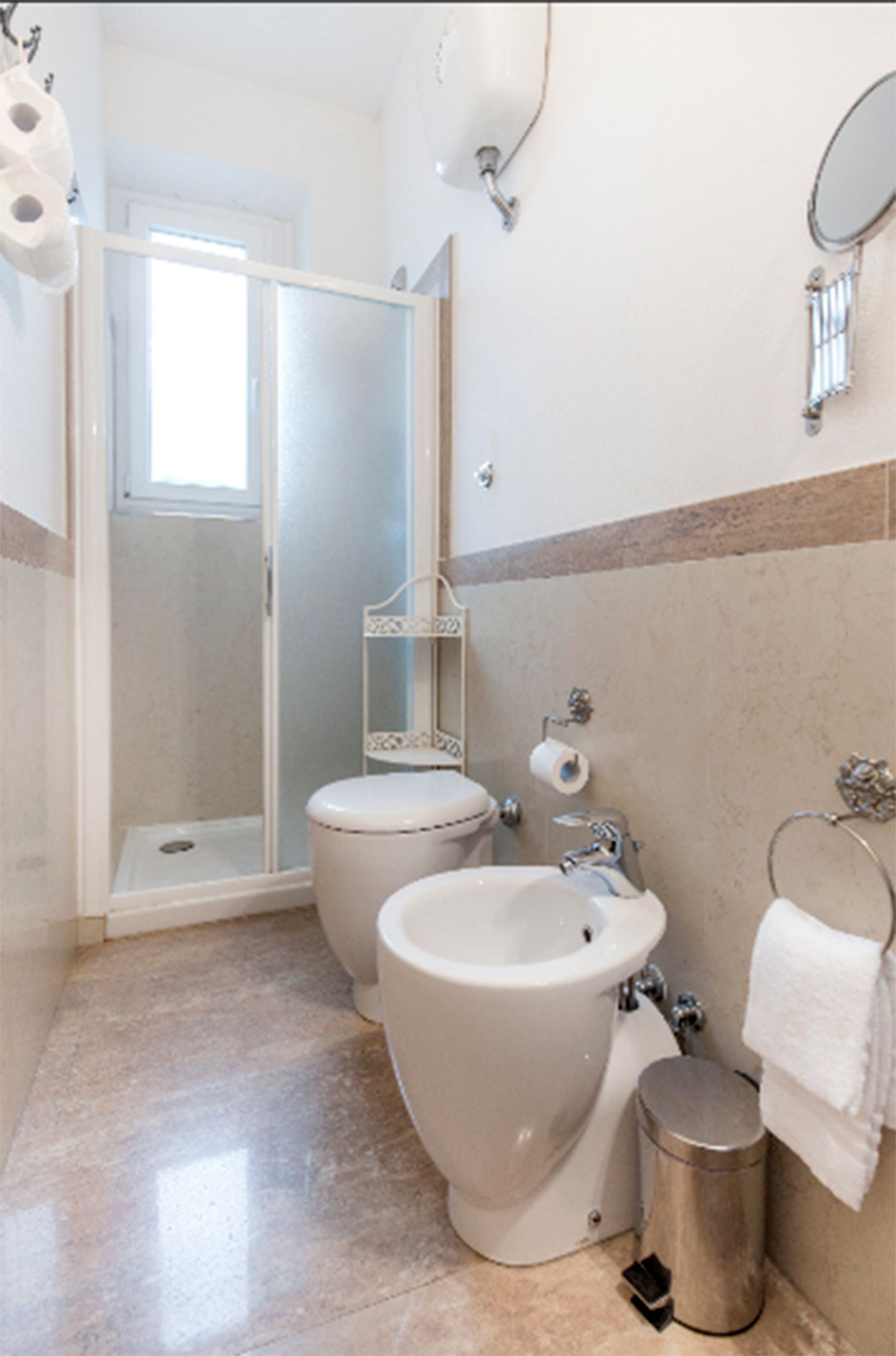 A bathroom with a toilet, bidet, and shower stall.