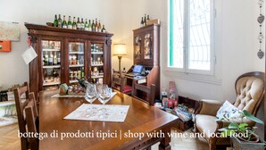 A dining area with a wooden table, wine bottles, and a cabinet with glass doors. - Gourmet B&B Villa Landucci (Florence)