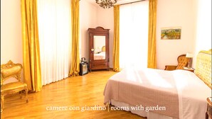 A bedroom with a large bed, wooden floor, a mirror, and a chandelier. - Gourmet B&B Villa Landucci (Florence)