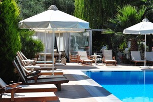 Una piscina al aire libre, sombrillas, sillones reclinables de piscina