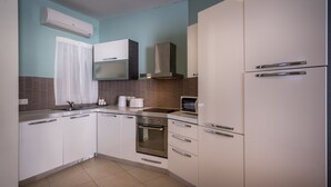 A modern kitchen with white cabinets, a stainless steel oven, a microwave, and a built-in range hood. - Consiglia Apartments - Sliema (Sliema)