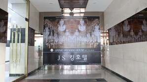 A hotel interior with a large poster advertising the Opinio Wedding House, featuring chandeliers and a luxurious interior. - King Hotel (Seongnam)