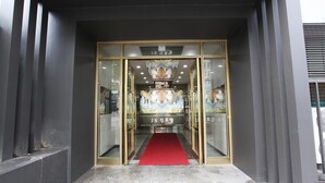 A hotel entrance with a red carpet leading to a reception area. - King Hotel (Seongnam)