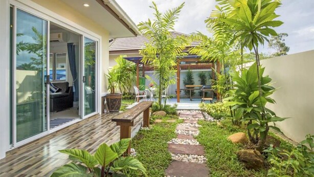 A modern house with a glass door leading to a patio area. - Aonang Sweet Blue Sea (Krabi)