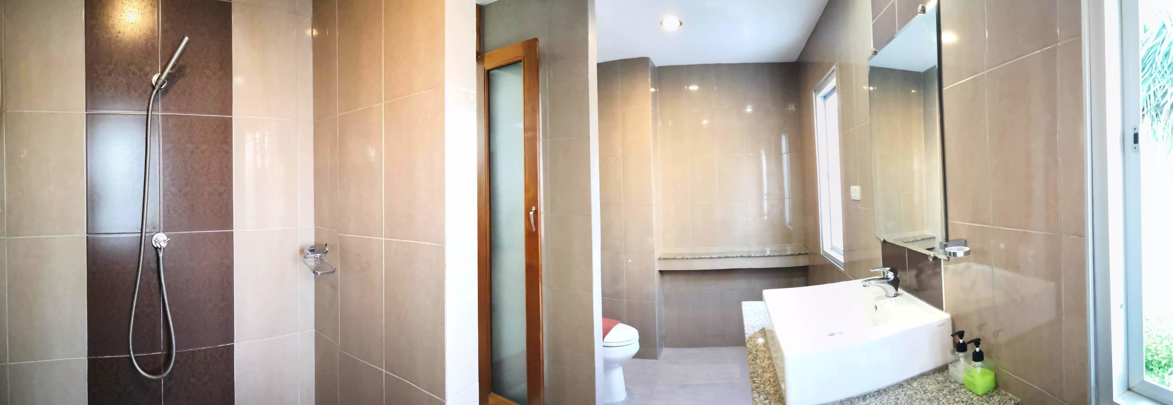 A modern bathroom with a shower, toilet, and sink.
