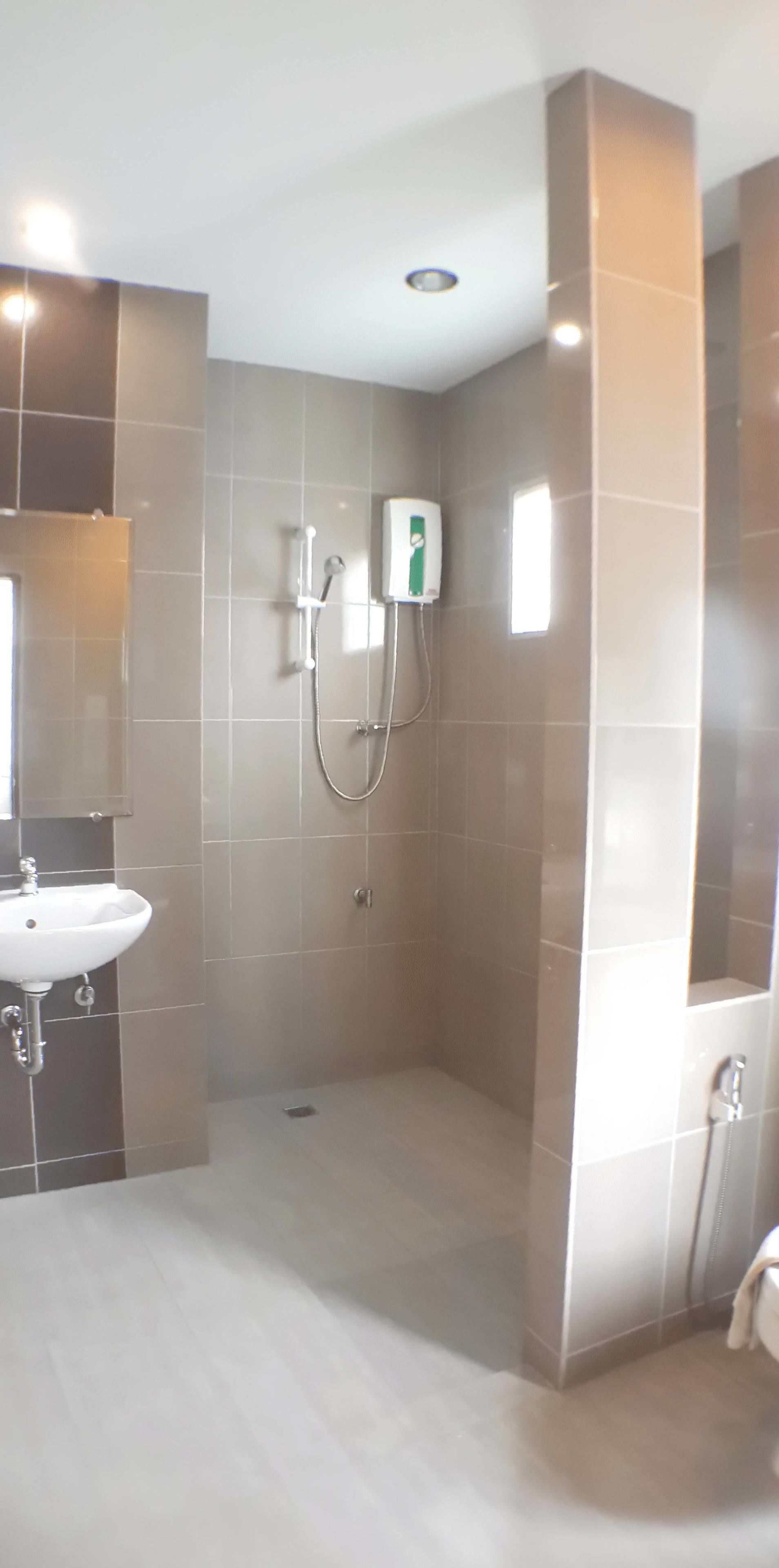 A modern bathroom with a shower, a sink, and a towel rack.