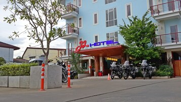 Un hotel con fachada azul, varios balcones y un letrero que dice 'Hotel'.