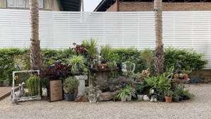 Un jardín con diversas macetas de plantas y esculturas.