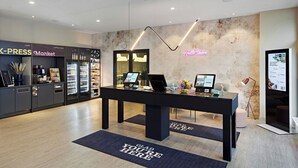A modern reception area with a black reception desk, a neon sign, and a digital display. - LEGERE EXPRESS Bielefeld (Bielefeld)