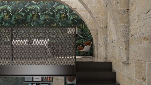 Un intérieur moderne avec un mur en pierre, un escalier et une bibliothèque contenant des livres et des objets décoratifs.