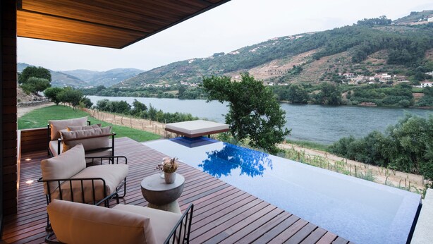 A wooden deck with outdoor furniture overlooking a lake and hills. - Quinta de S. Bernardo Winery & Farmhouse (Mesão Frio)
