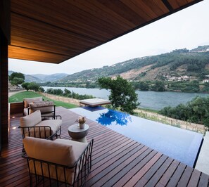 A wooden deck with outdoor furniture overlooking a lake and hills. - Quinta de S. Bernardo Winery & Farmhouse (Mesão Frio)