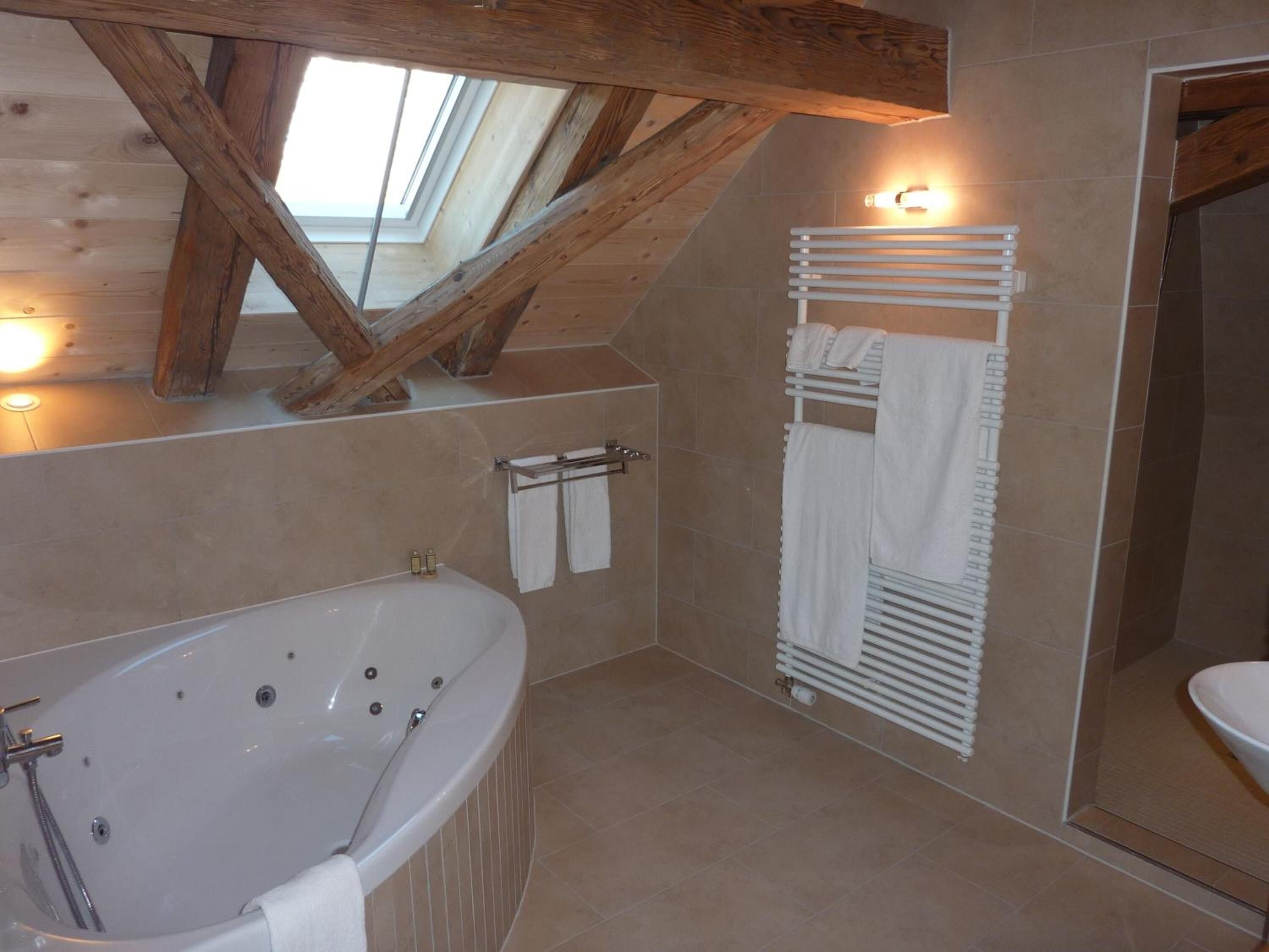 A bathroom with a freestanding bathtub, a towel rack, and a mirror.