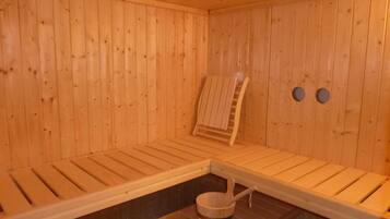 A wooden sauna with benches and a wooden bucket.