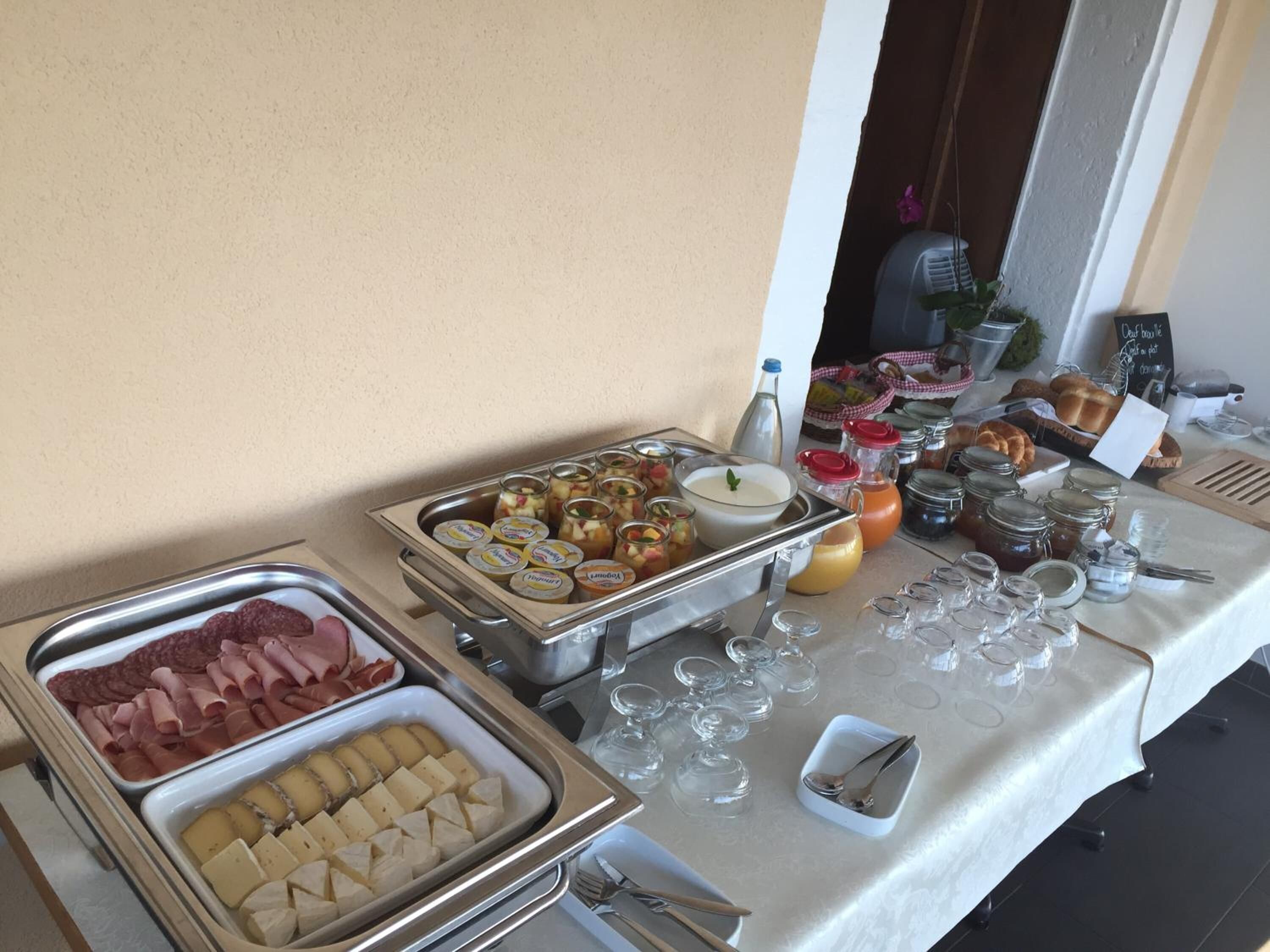 Una mesa de buffet con diversos alimentos, incluyendo carnes, quesos y salsas.