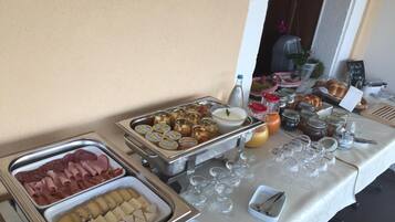 Una mesa de buffet con diversos alimentos, incluyendo carnes, quesos y salsas.