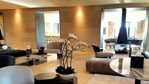 A modern living room with a sofa, coffee table, and a potted plant. - Etoile de Pompadour (Beyssac)