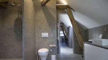 A modern bathroom with a shower, toilet, and sink.