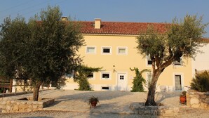A two-story building with a red-tiled roof, a stone pathway, and potted plants. - Retiro do Bosque Country House (Alcanena)