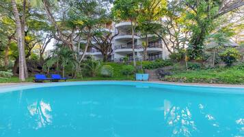 Een buitenzwembad en ligstoelen