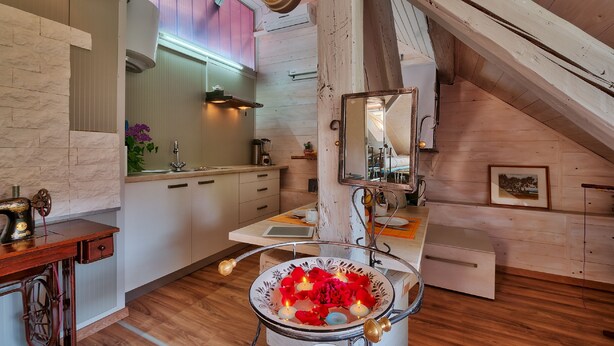 A cozy attic bedroom with a wooden ceiling, a large mirror, and a rustic aesthetic. - Anastasia Suites Zagreb (Zagreb)