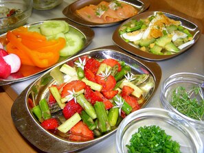 Diverse gerechten op een tafel, waaronder salades en een bord gerookte zalm.
