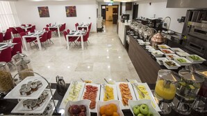 A buffet setup with various food items and beverages, a kitchen area with appliances, and a seating area with tables and chairs. - The Town Hotel Doha (Doha)