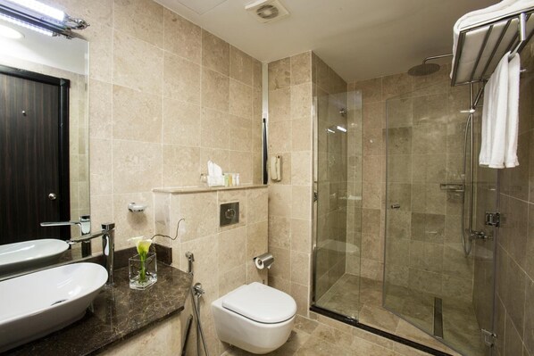 Un baño moderno con un lavamanos grande, inodoro y ducha con cerramiento de vidrio.