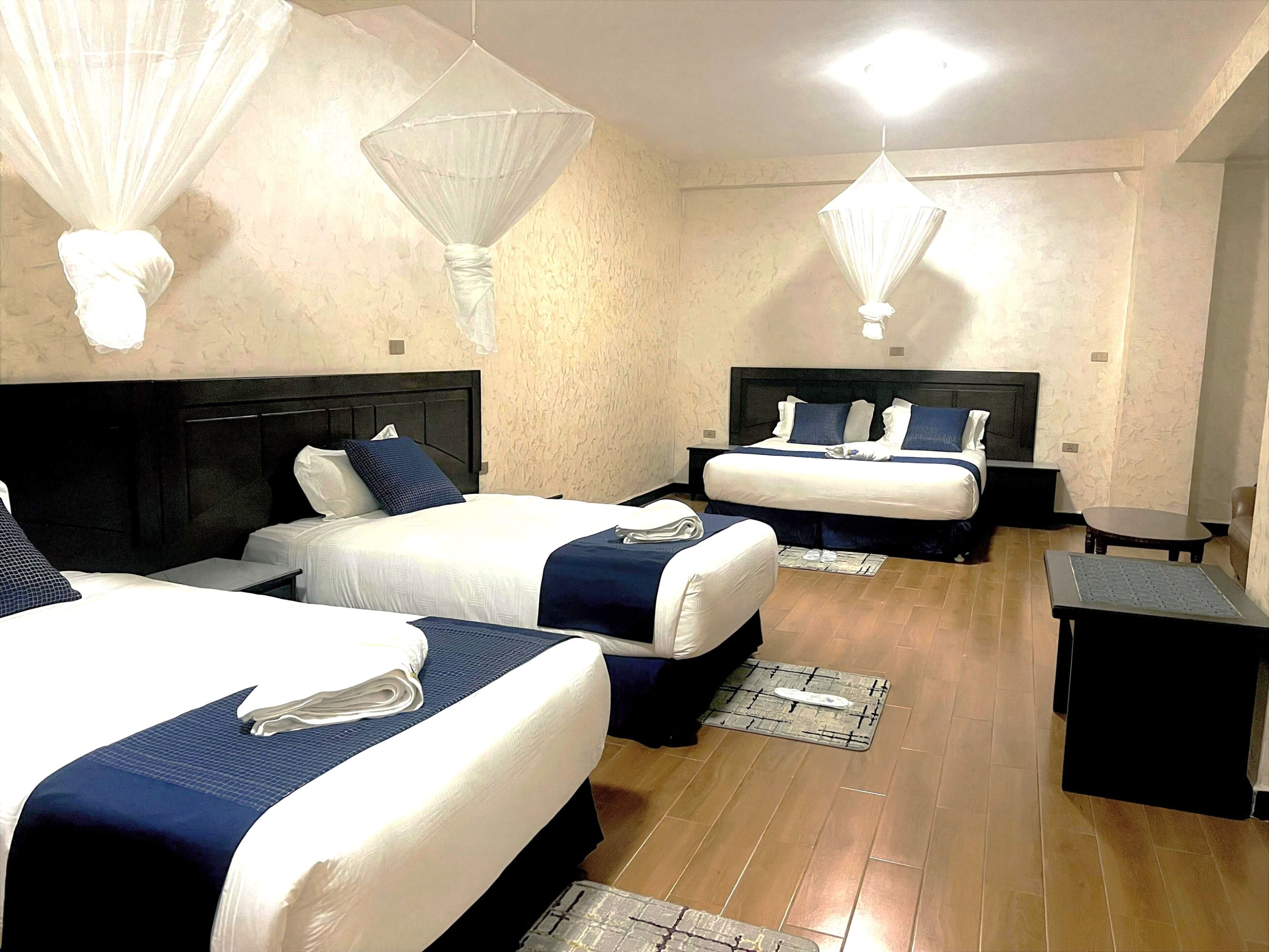 Ein Hotelzimmer mit zwei Betten, einem kleinen Tisch und einem Nachttisch.