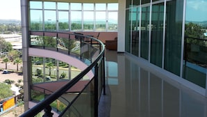A modern building with a curved balcony, large windows, and a view of a green landscape. - Delano Hotel (Bahir Dar)
