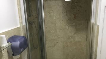 A small bathroom with a shower, sink, and toilet.