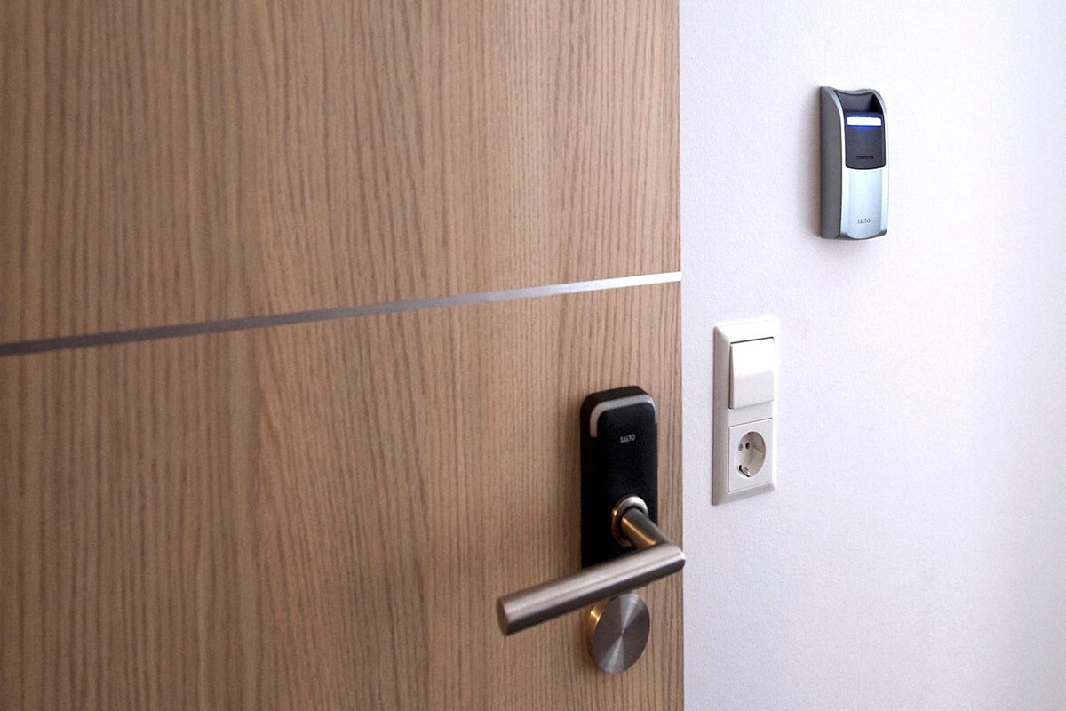 Una puerta moderna con cerradura de llave y teclado electrónico en la pared.