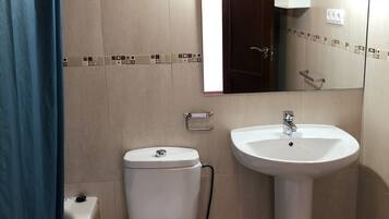 A bathroom with a toilet, sink, and bathtub.
