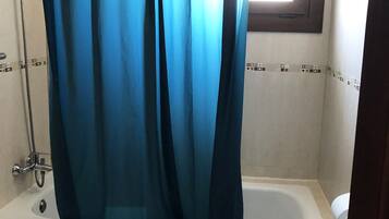 Un baño con bañera, ducha e inodoro.