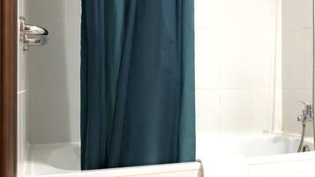 Un baño con bañera, ducha y un taburete verde.