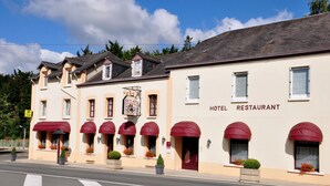 A hotel with red awnings and a sign indicating it is a restaurant. - Hôtel la Croix Couverte (Mayenne)