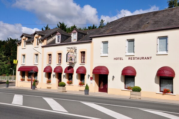 A hotel with red awnings and a sign indicating it is a restaurant. - Hôtel la Croix Couverte (Mayenne)