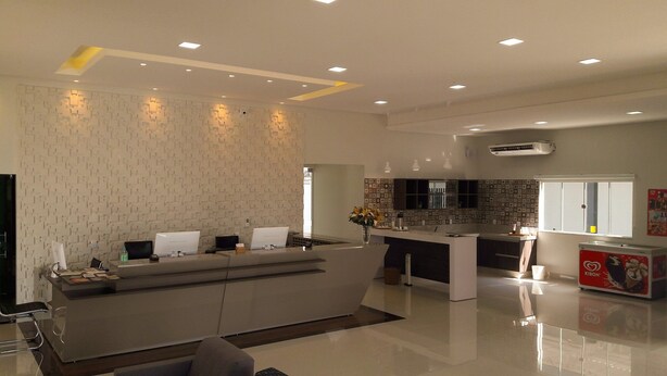 A modern kitchen with a central island, built-in appliances, and a patterned backsplash. - Hotel Mandino (Alta Floresta)