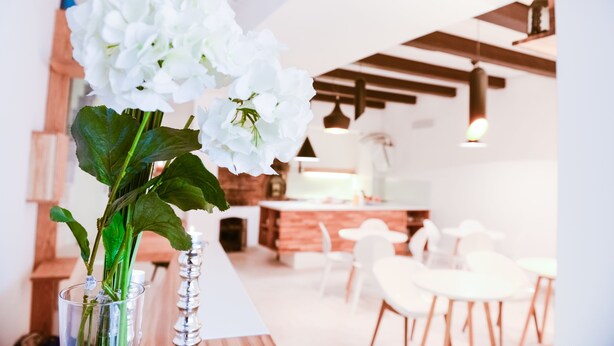 A modern kitchen with white cabinets, a central island, and pendant lighting. - Hotel Old Sarajevo (Sarajevo)